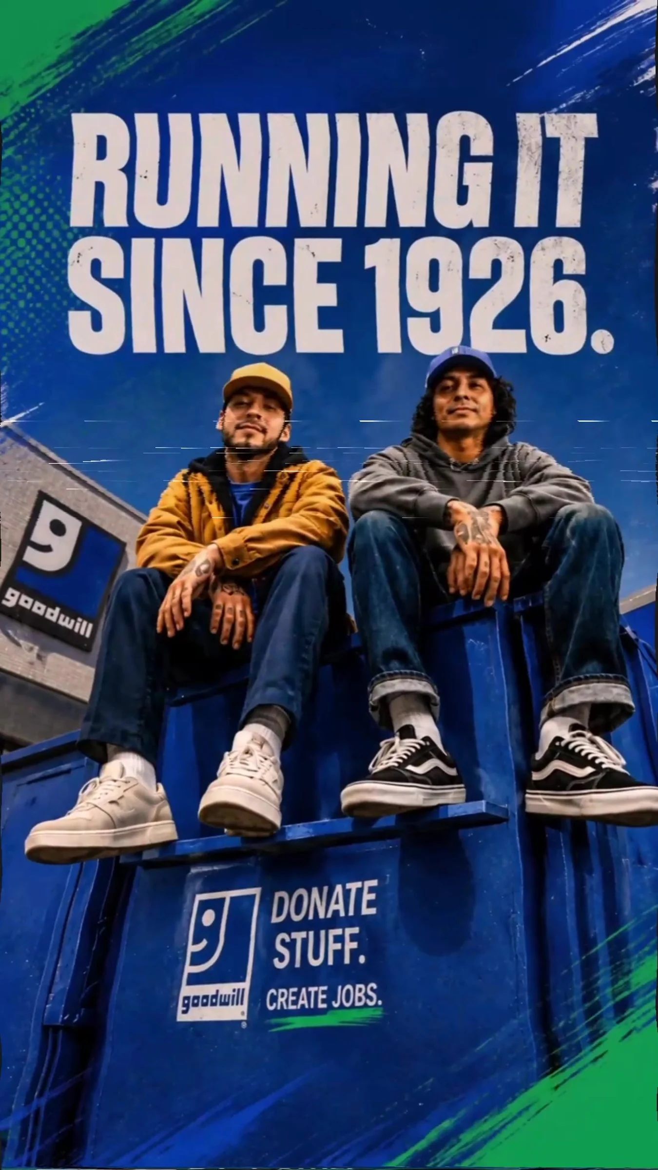 OG Recyclers video frame: Running it since 1926 above two men in caps sitting on a blue Goodwill donation bin.